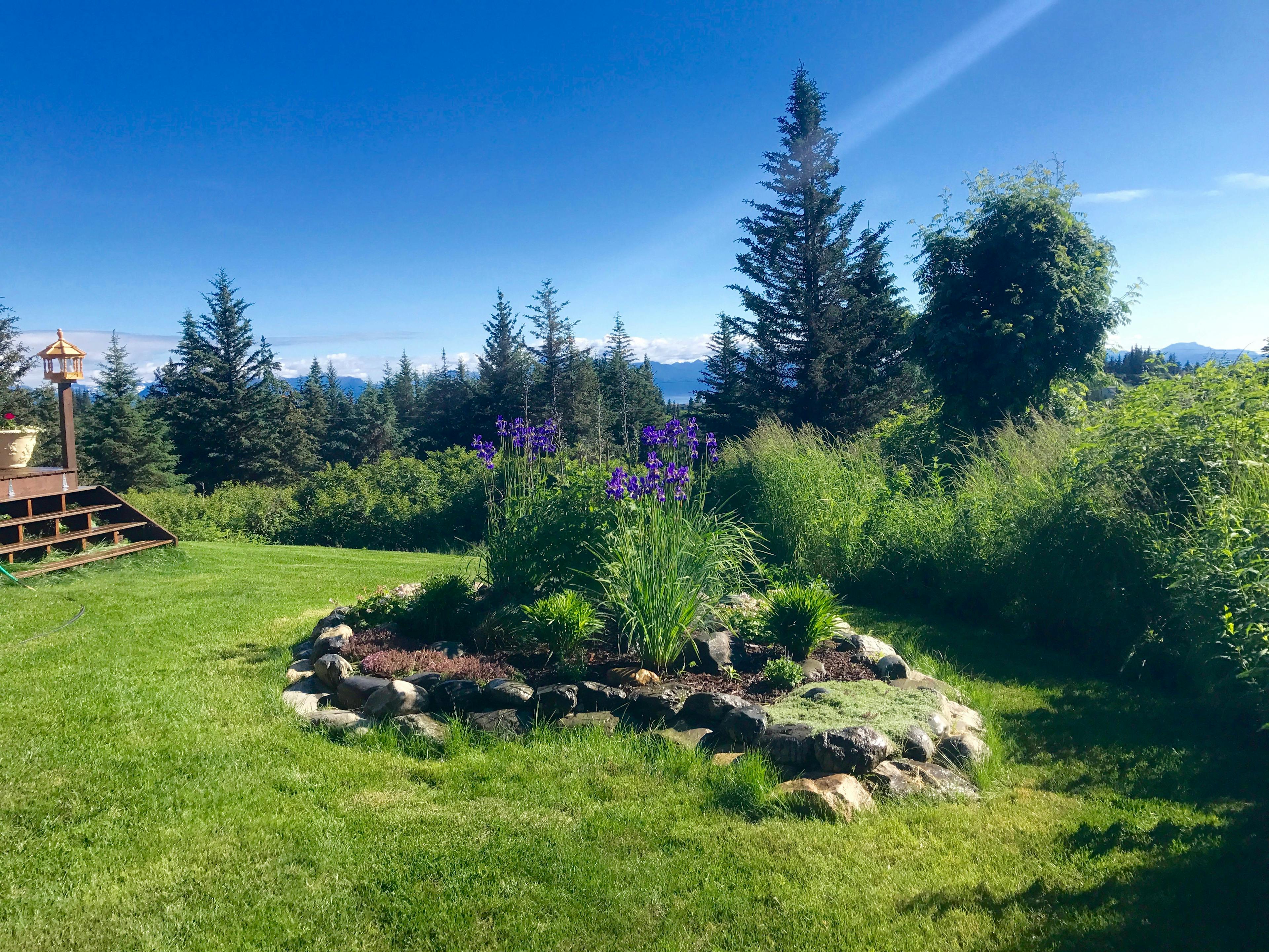 One of the beautiful gardens at Cozy Cove Inn with a brilliant blue sky and a thin cloud streak.