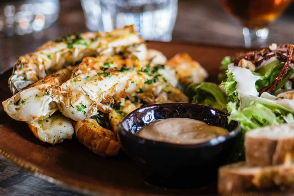 Delicious plate of seafood with a dipping sauce and fresh green salad