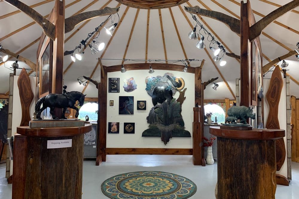 Interior of a rustic art gallery showing various sculptures and pieces of art on display